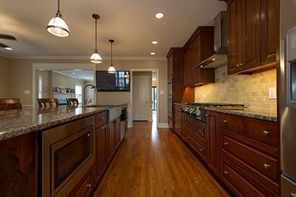 Kitchen with wood cabinets, granite countertops, stainless steel appliances, and hardwood floors.