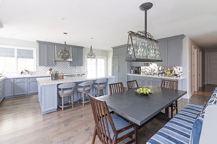 Spacious gray kitchen with island, dining table, and wood floor.