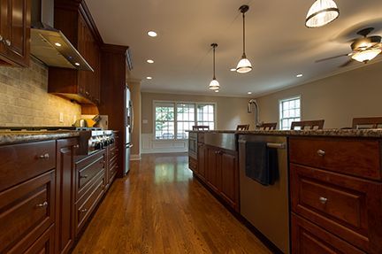 Kitchen with wooden cabinets, stainless steel appliances, granite countertops, and hardwood floors.