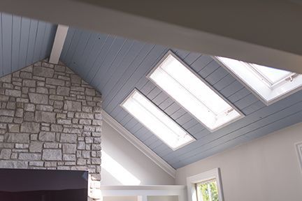 Vaulted ceiling with blue-painted wood and skylights. Stone fireplace.