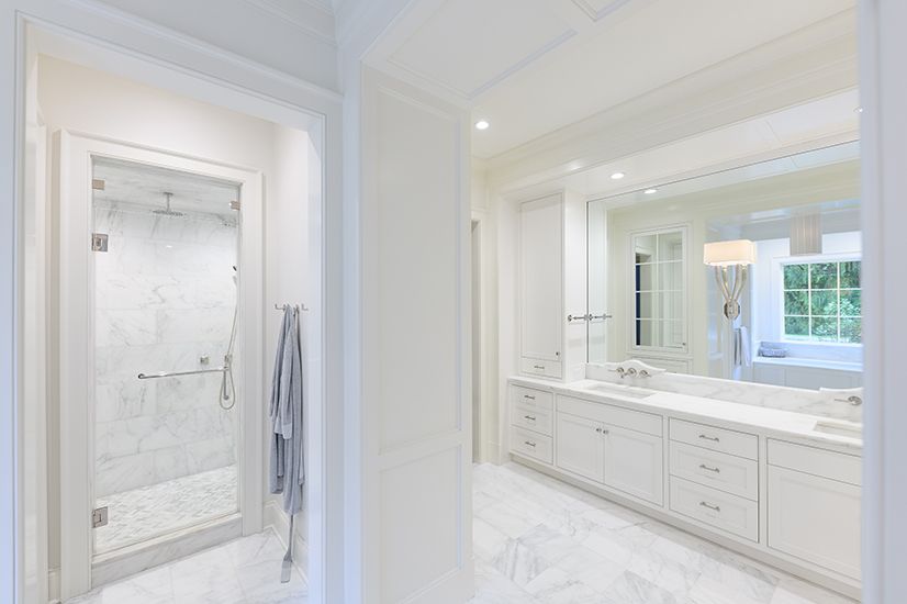 White marble bathroom with shower and vanity, bright and airy.