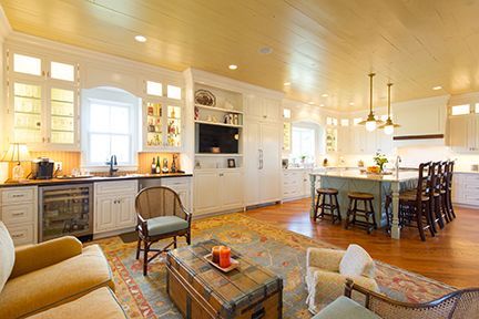 Open-concept kitchen/living room with white cabinets, a central island, and a wood floor.