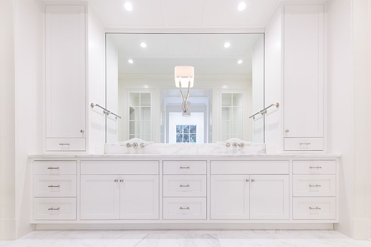 White bathroom vanity with mirror and cabinets.