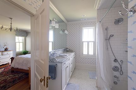 Bathroom with vanity, shower, and doorway leading to a bedroom. Blue and white color scheme.