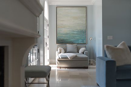 Light blue room with chaise lounge, large artwork, and a glimpse of a sofa.