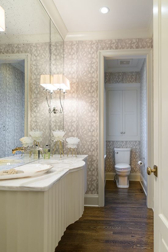 Powder room: marble vanity, ornate wallpaper, recessed toilet, hardwood floors.