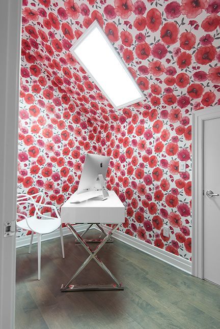 Home office with red floral wallpaper, white desk, chair, and a skylight.
