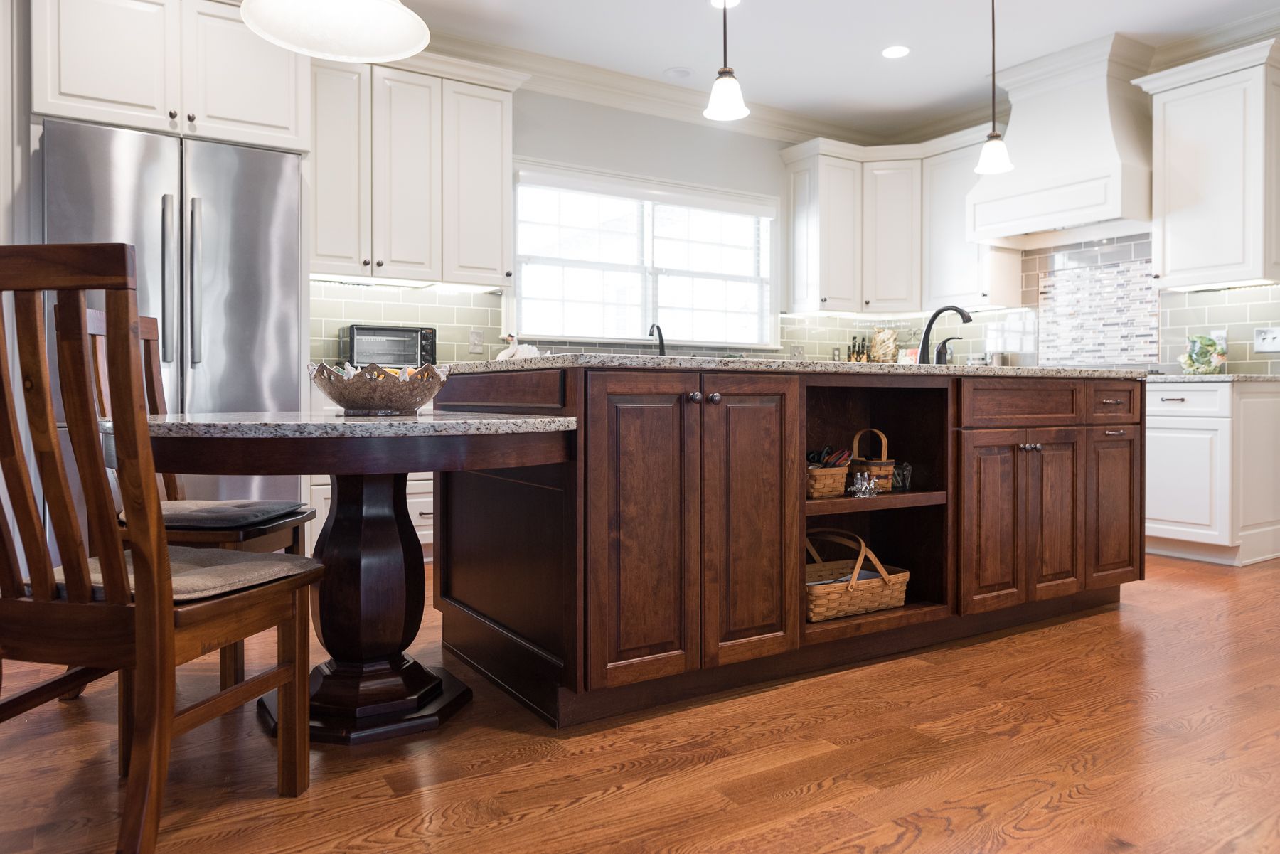 Kitchen with a dark wooden island, granite countertop, and stainless steel appliances.