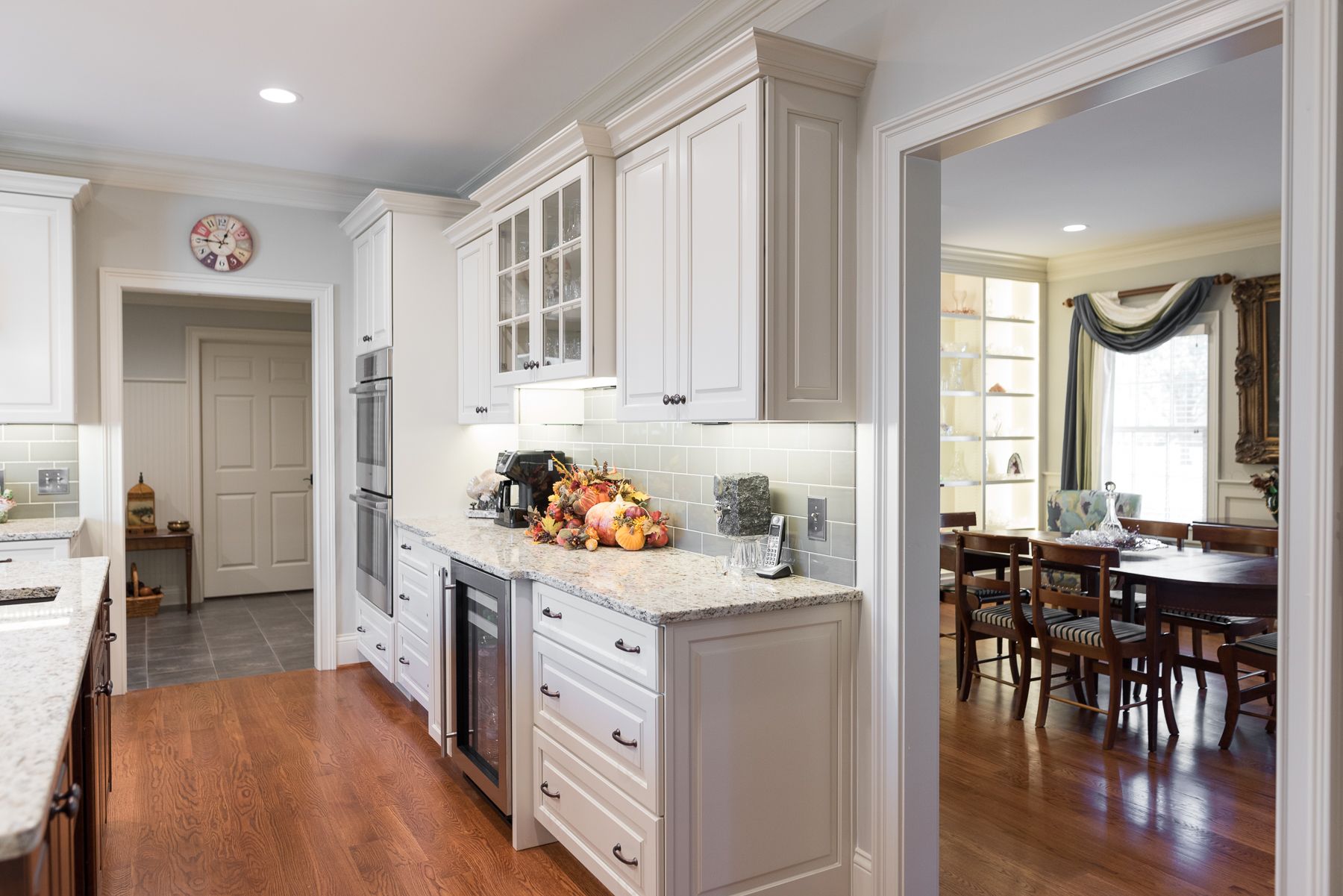 White kitchen with granite countertops, cabinets, and view into dining room.