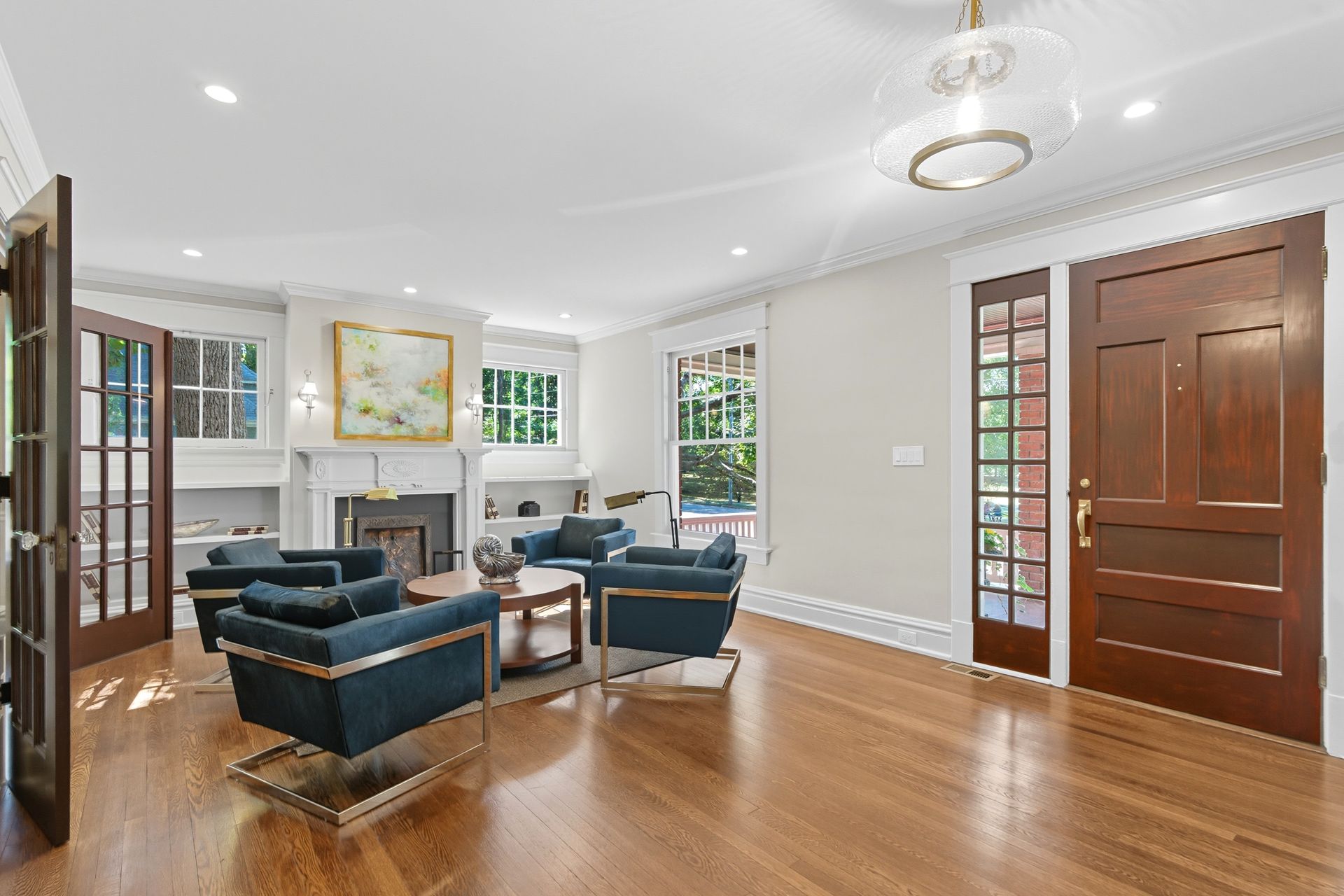 Living room with blue armchairs, a fireplace, and hardwood floors.