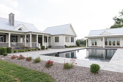 White farmhouse with a pool.