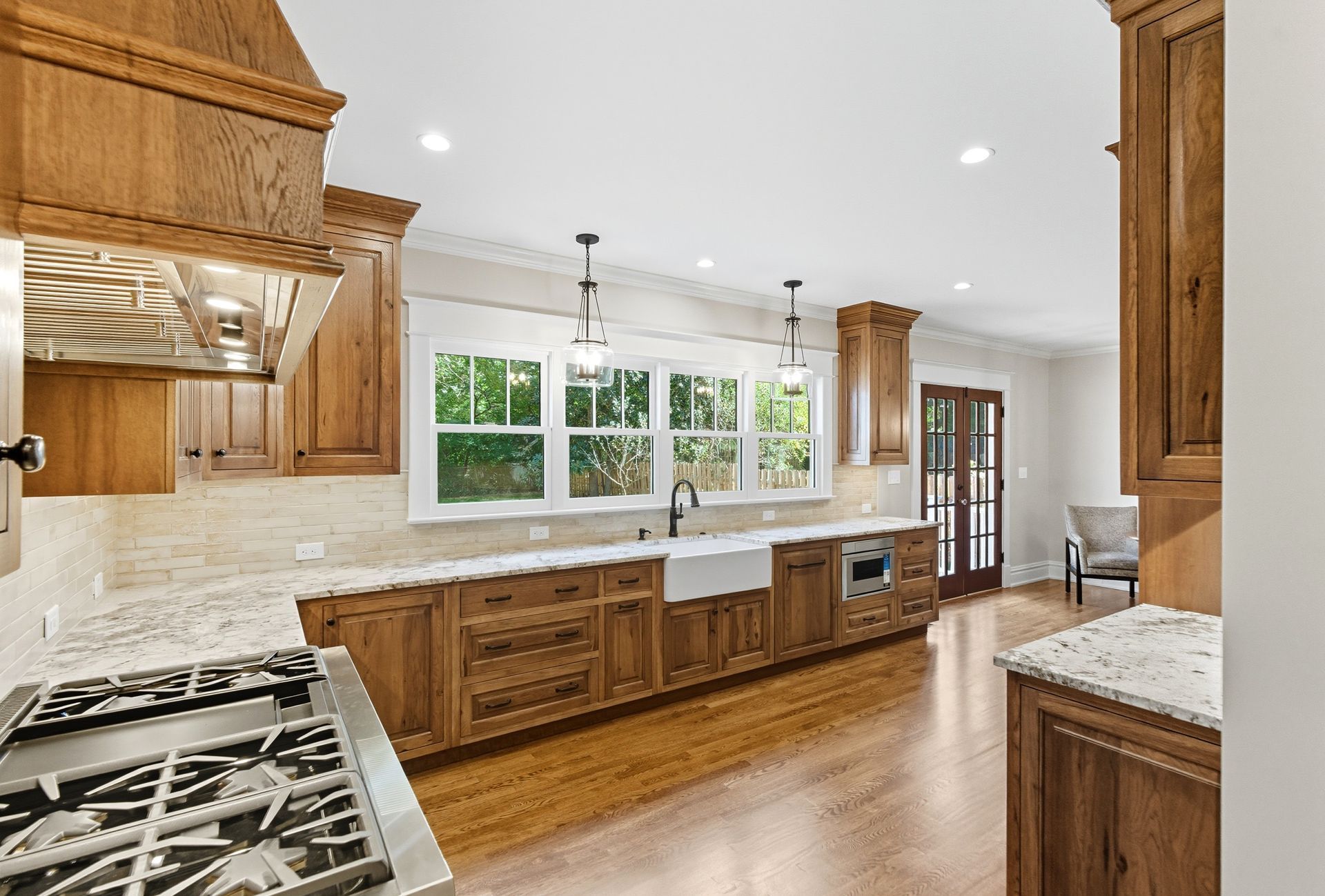 A kitchen with oak cabinets, white countertops, and a gas stove.