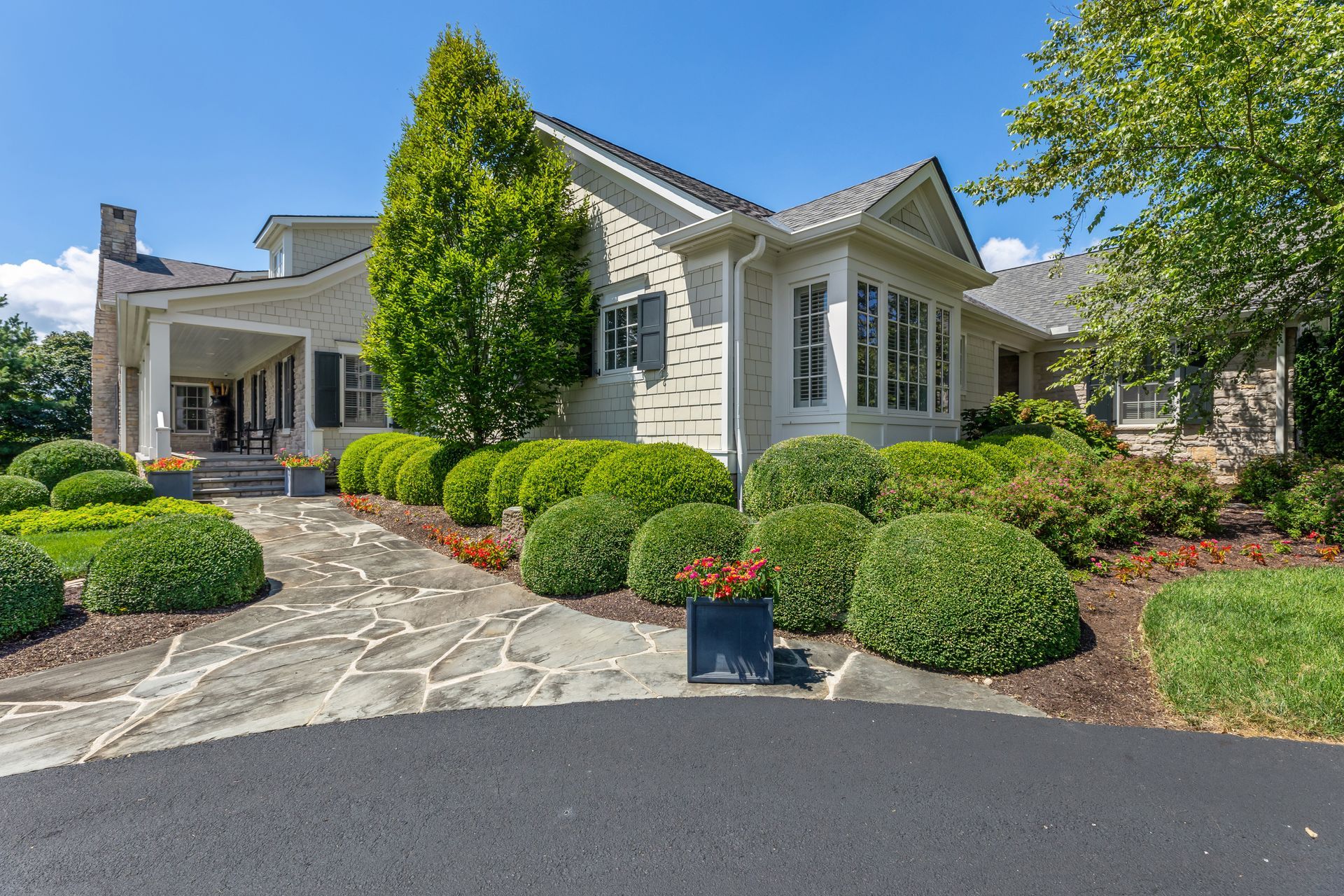 House exterior with landscaped front yard, stone walkway, and a blue sky.