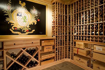 Wine cellar with wooden racks, bottles, and crates. Features a large coat of arms on a black backdrop.