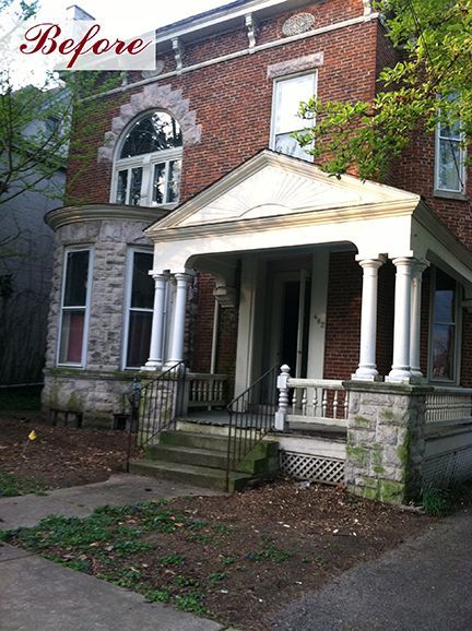 Brick two-story house with porch, front steps, and arched window. 