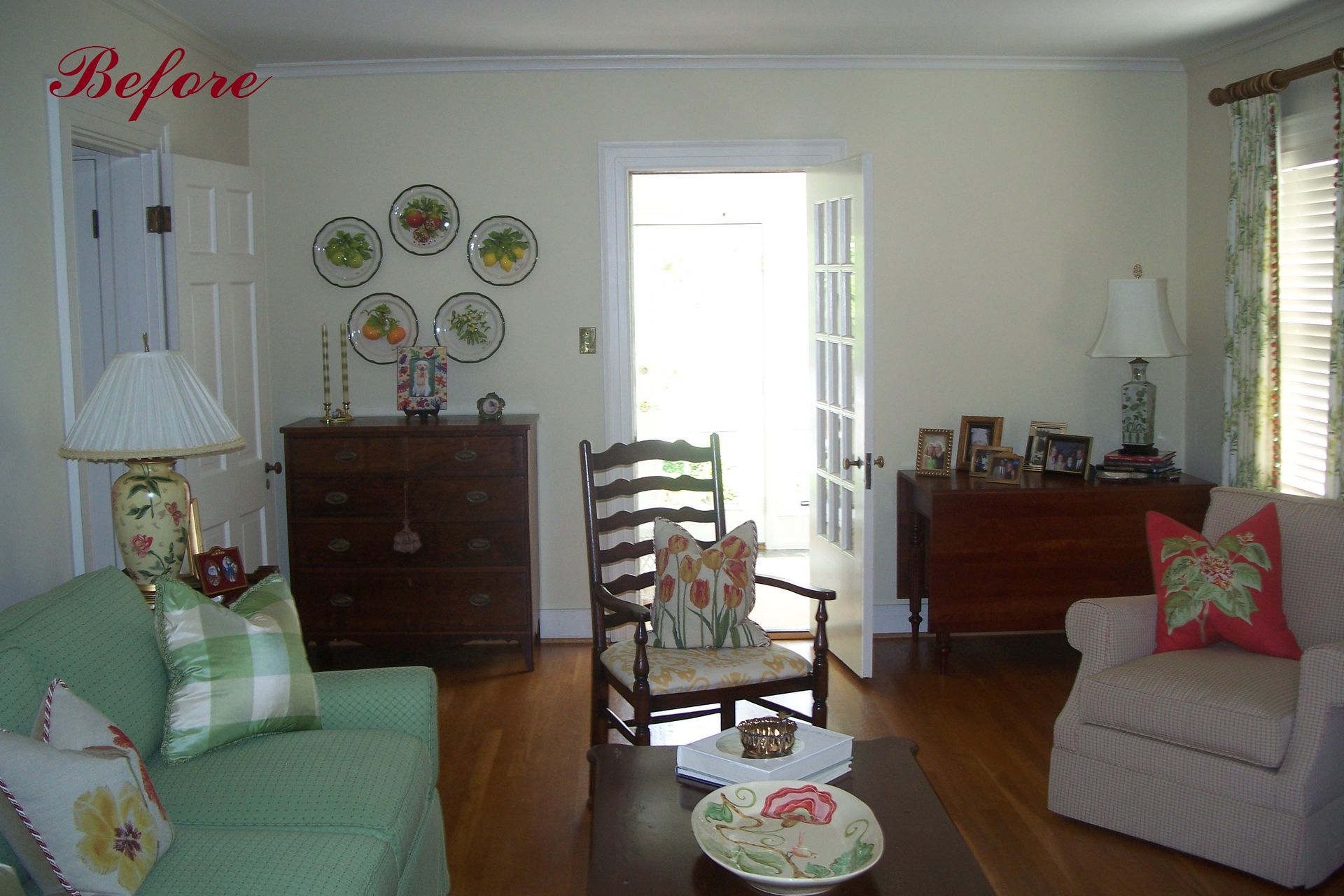Living room before renovation: green sofa, cream armchair, wooden furniture, French doors.