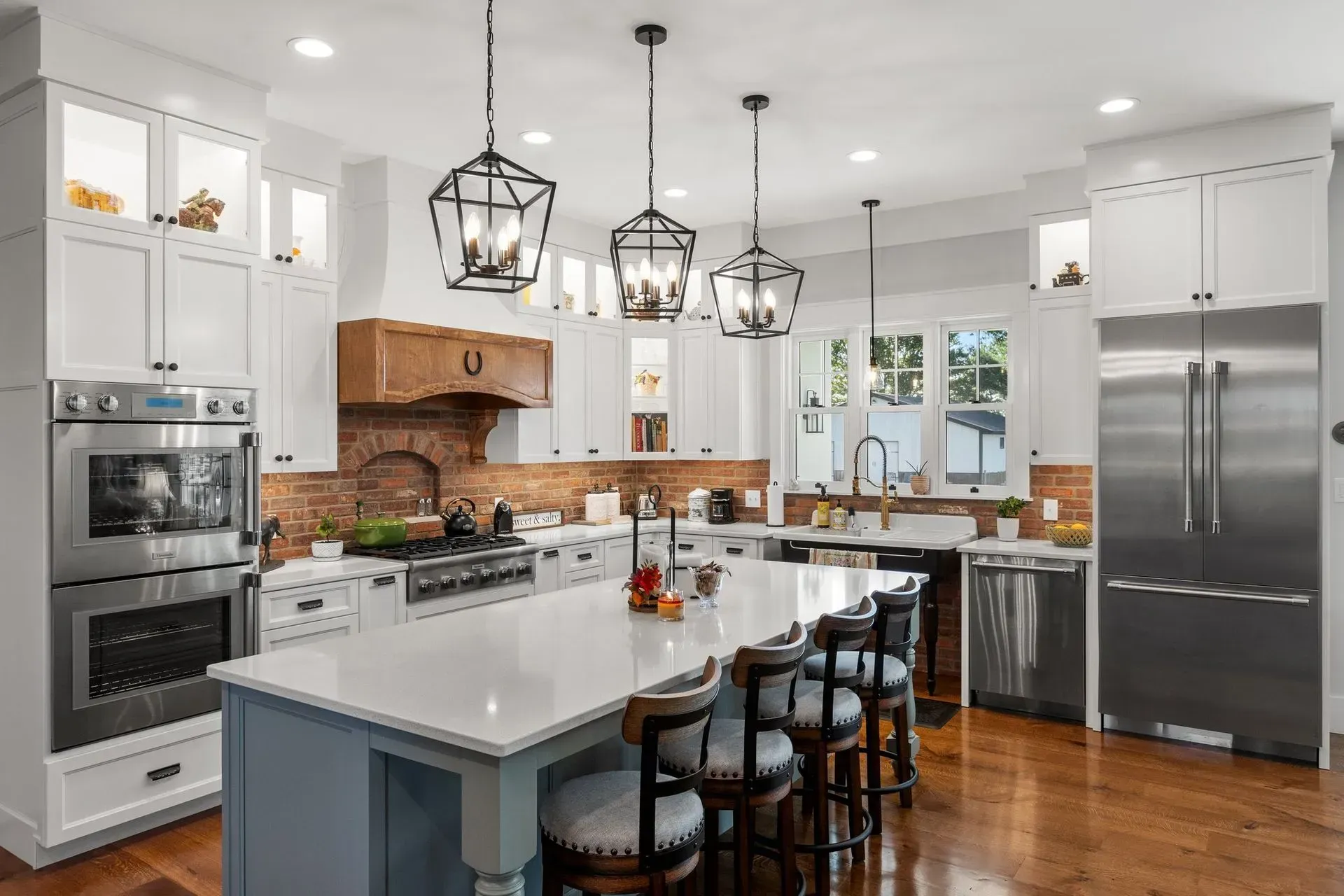 Spacious, modern kitchen with white cabinets, a large island, and stainless steel appliances.