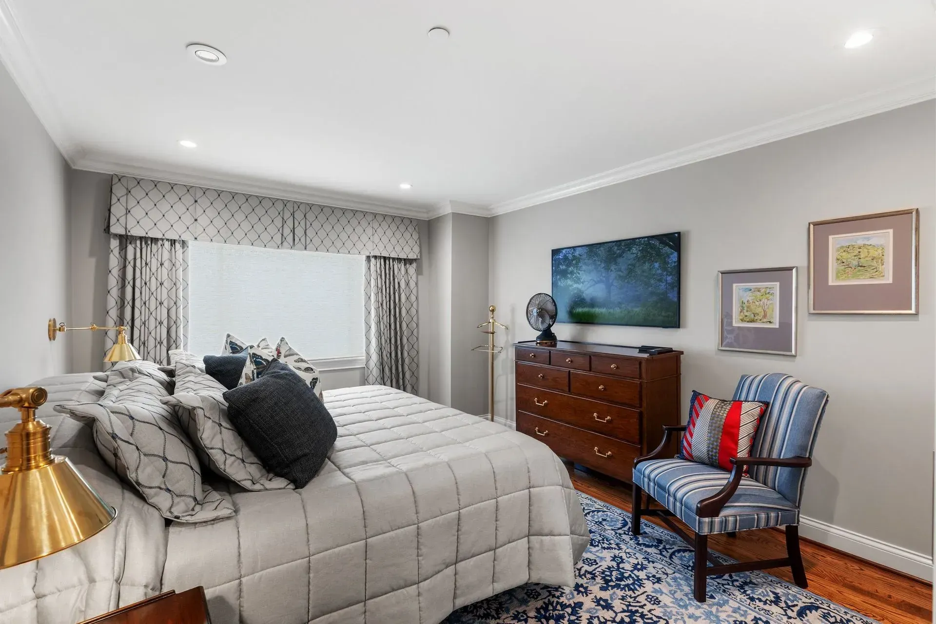 Bedroom with gray walls, bed, dresser, chair, window.