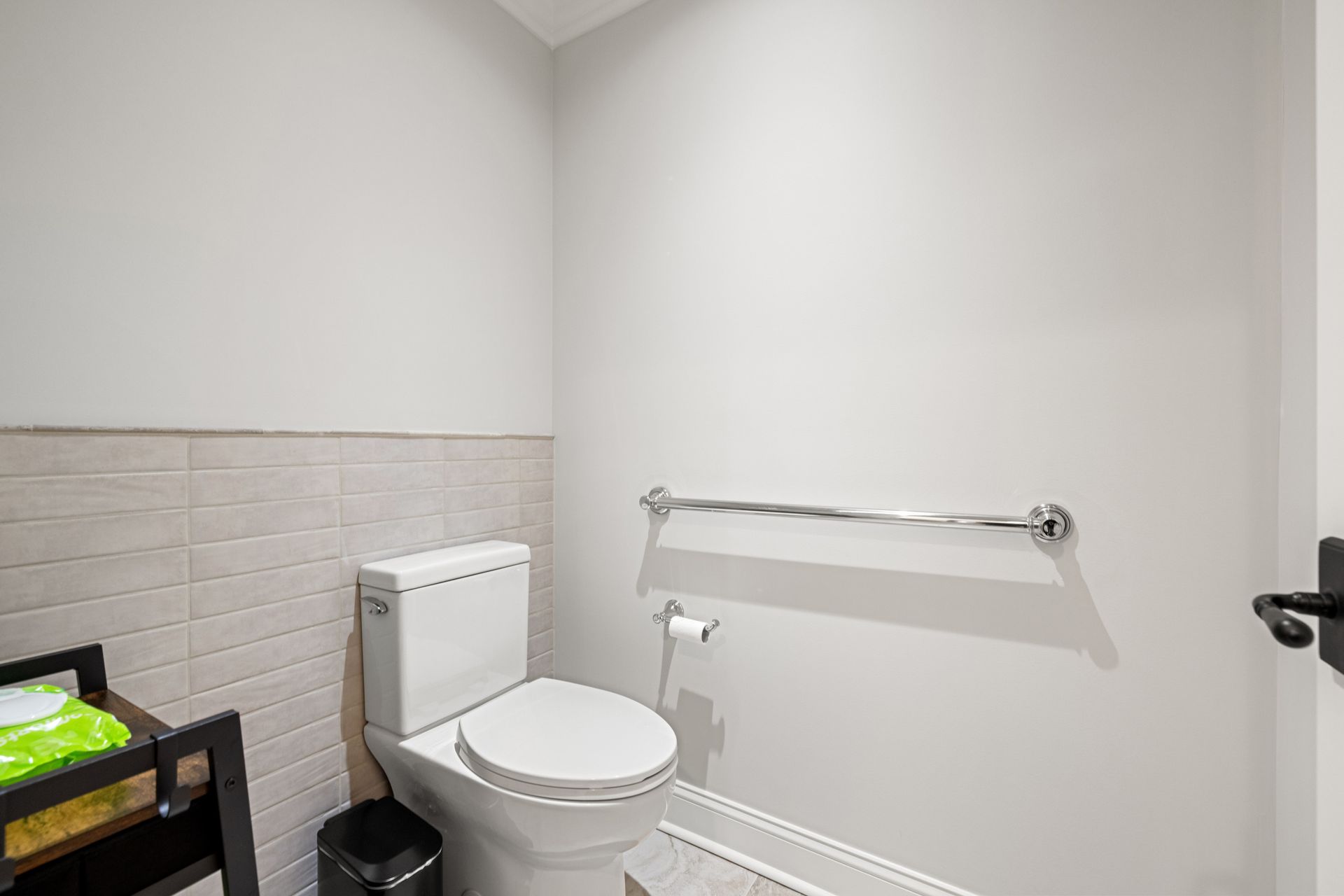Bathroom with toilet, grab bar, and gray walls.