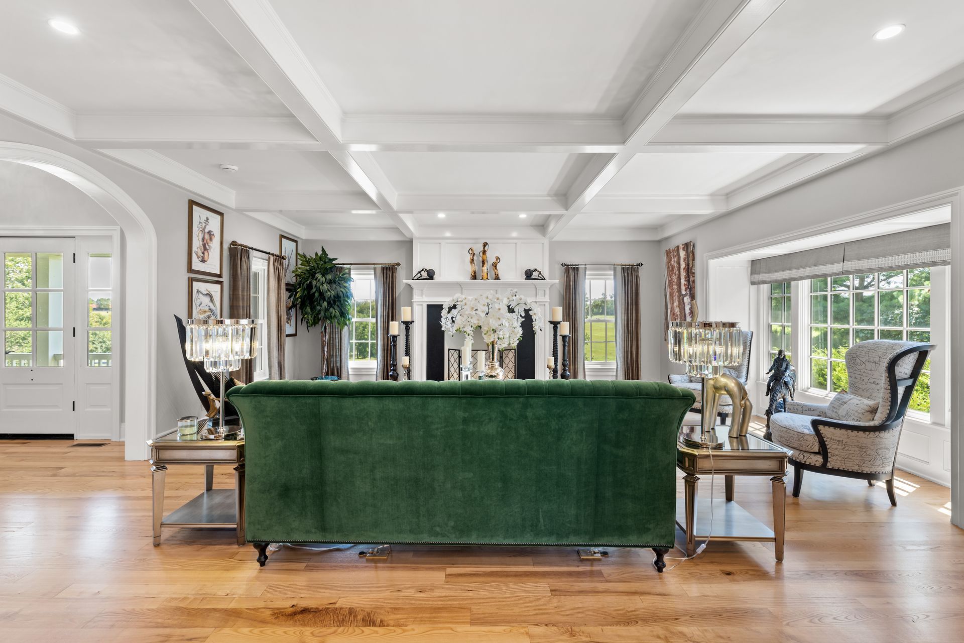 Living room with green sofa, wood floors, and white accents.