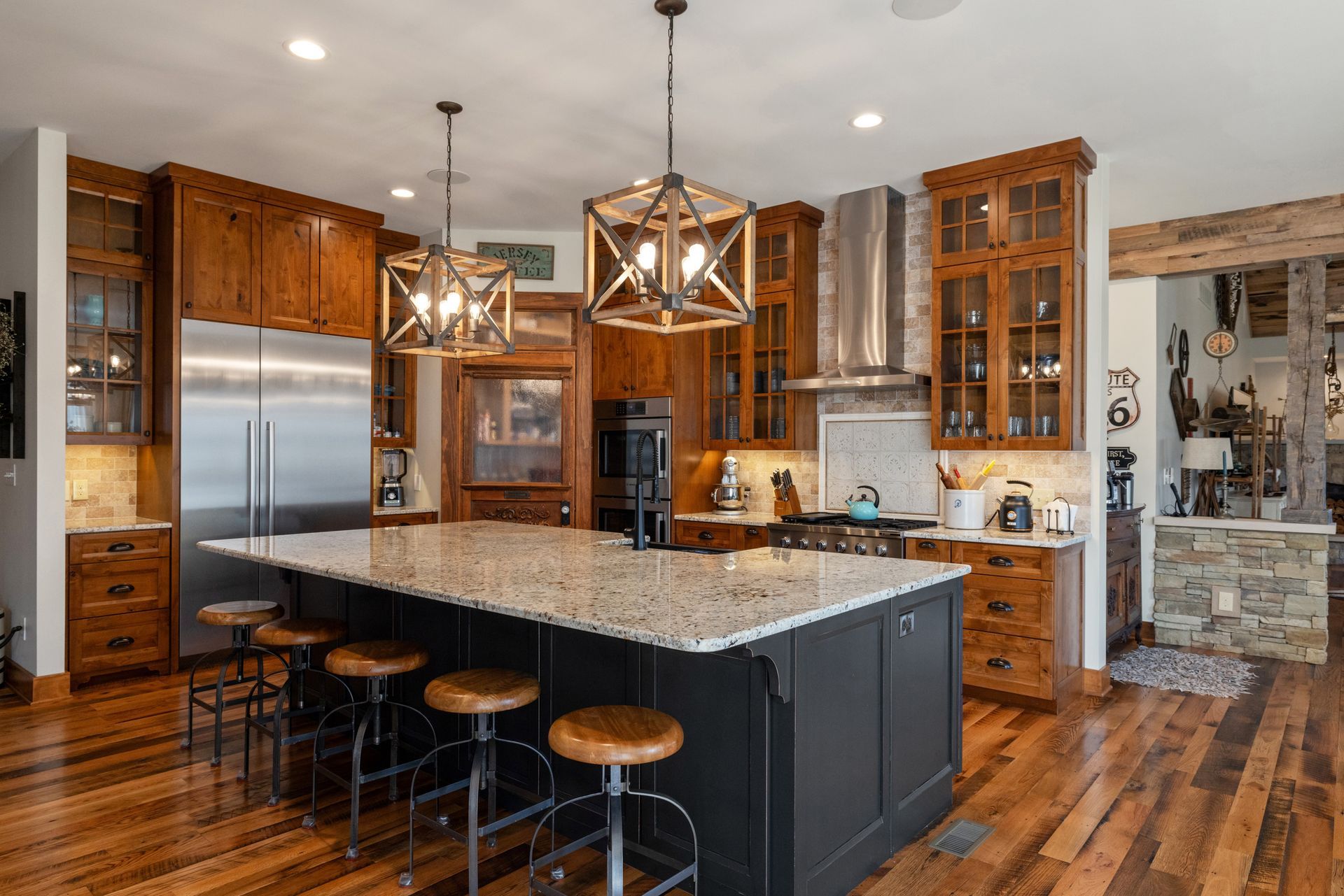 A modern kitchen with dark wood cabinetry, stainless steel appliances, and a large island with seating.