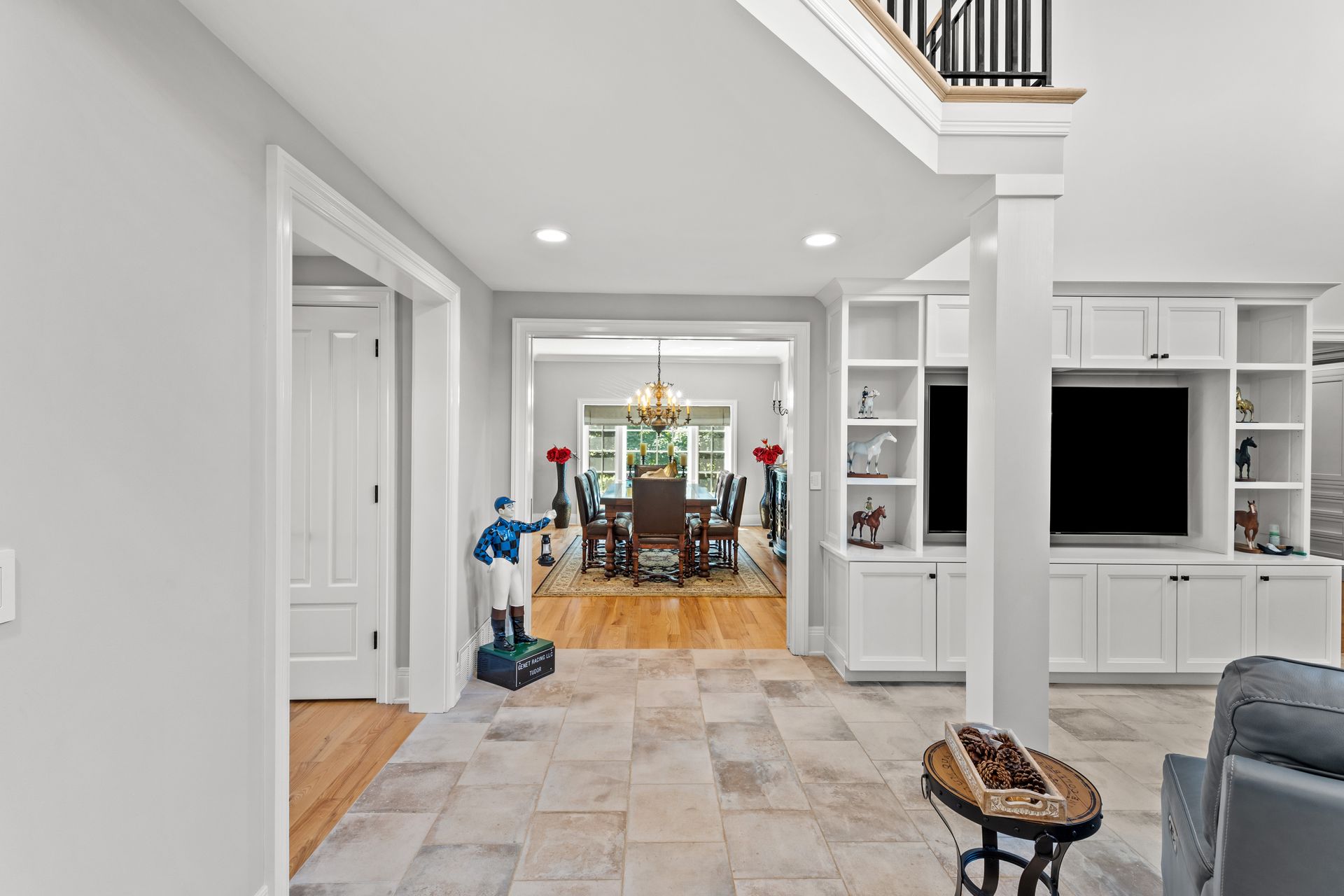 Spacious interior with tile floor, built-in cabinets, and dining area visible through an arched doorway.