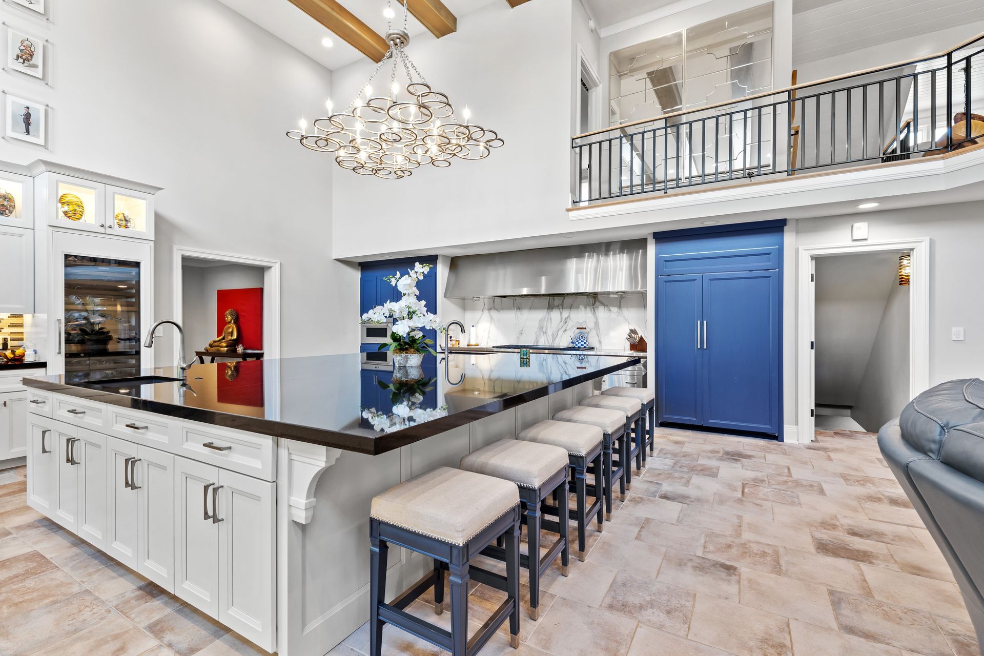 Spacious modern kitchen with large island, blue refrigerator, and a balcony.