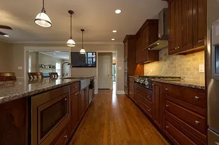 Spacious kitchen with dark wood cabinets, granite countertops, and hardwood floors.