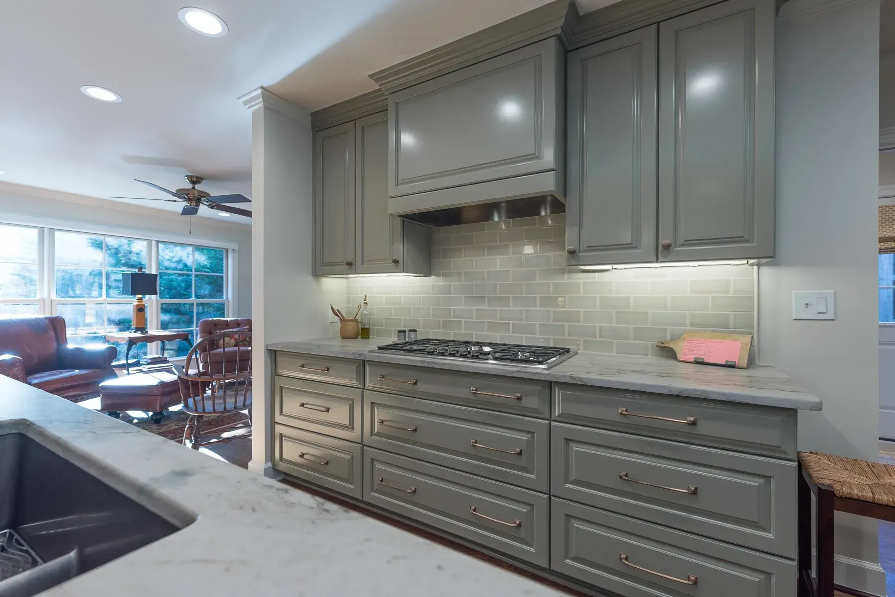 Gray kitchen cabinets with a light gray backsplash and countertops.