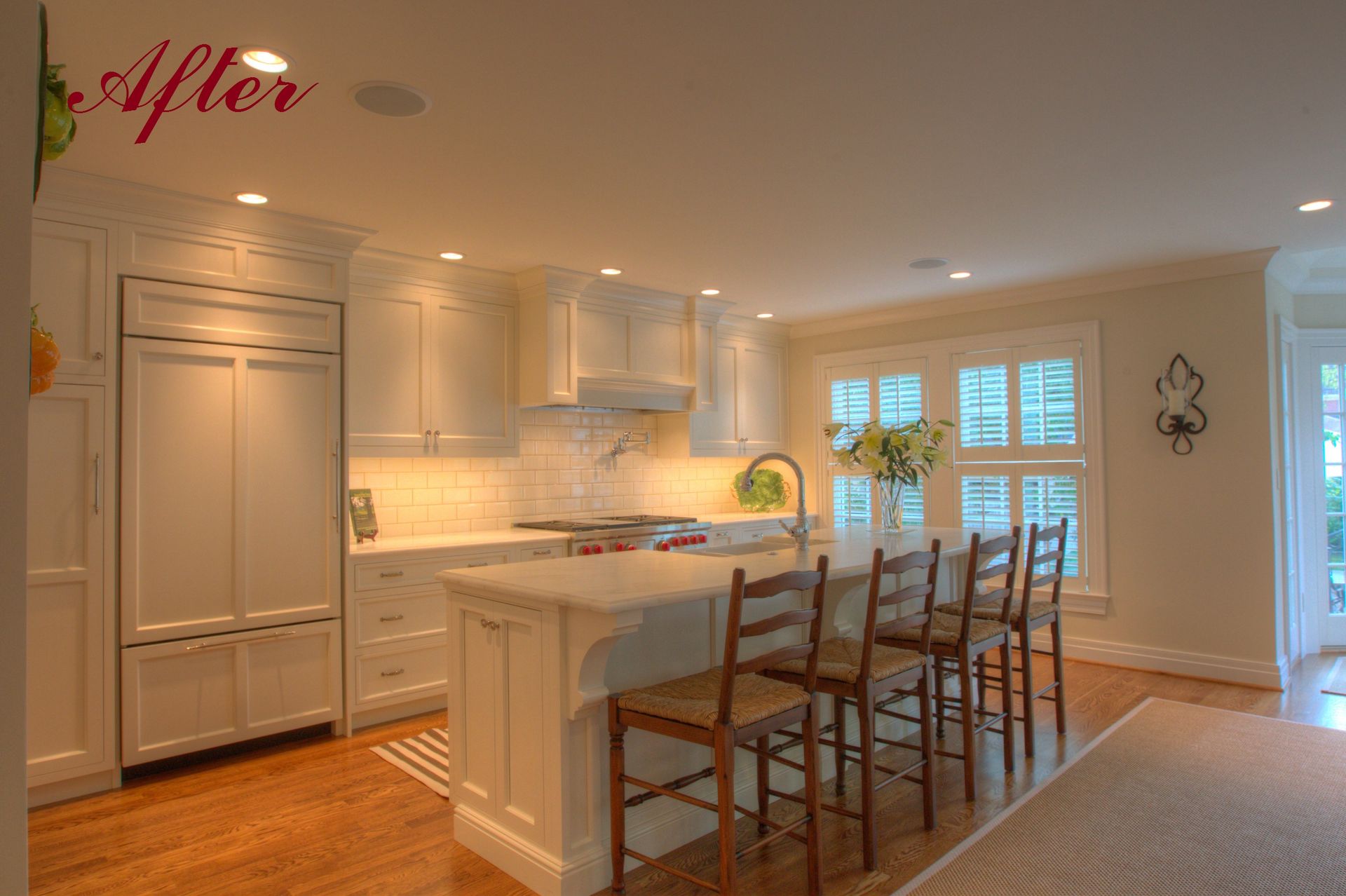 Bright, renovated kitchen with white cabinets, island with bar stools, and natural light.