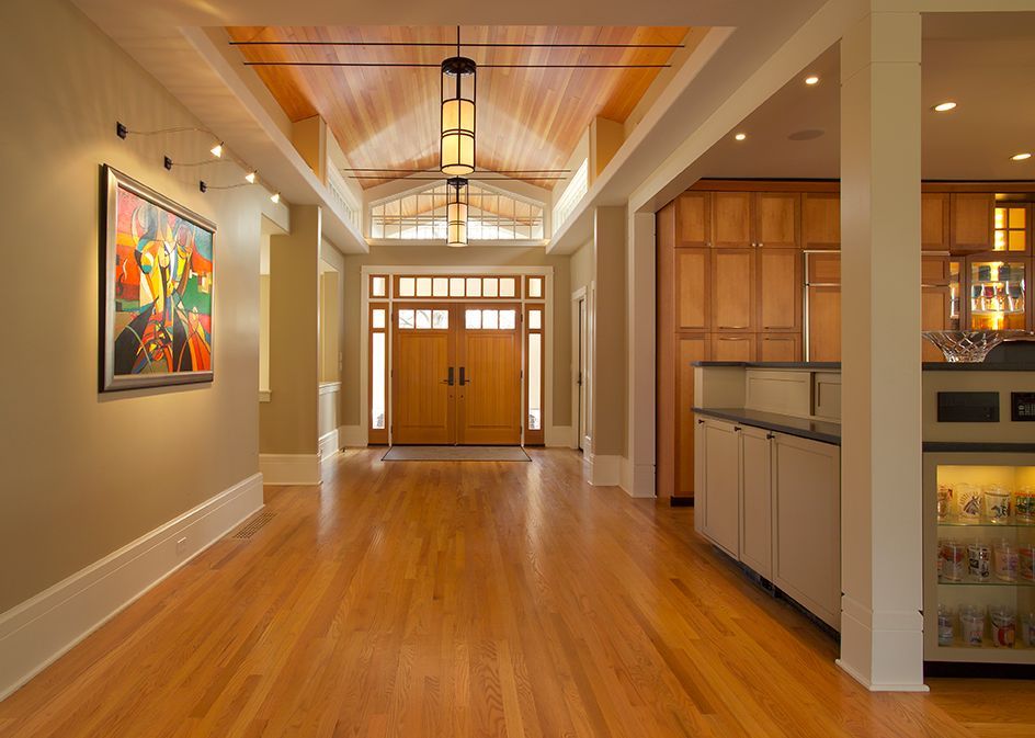 Hallway with wood floor, walls, and door. Colorful abstract painting on left wall.