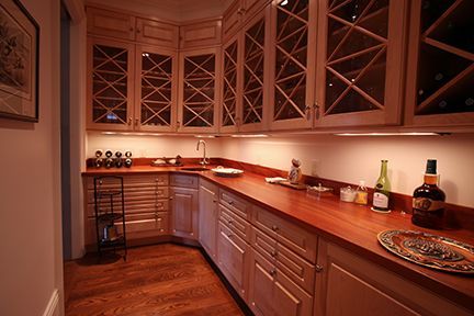 Wine storage room with wood cabinets, countertops, and flooring.