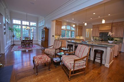 Open-concept kitchen and living space with hardwood floors, seating area, and dining table.
