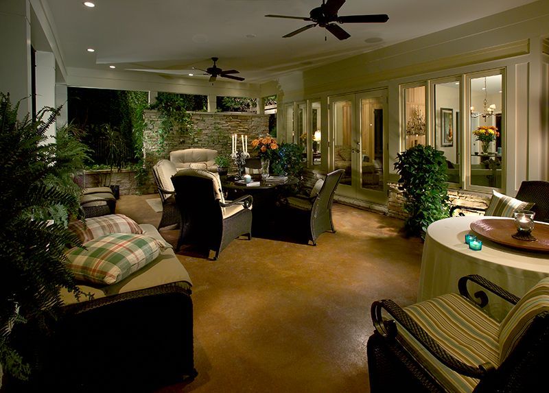 Patio with seating, dining table, plants, and soft lighting at dusk.