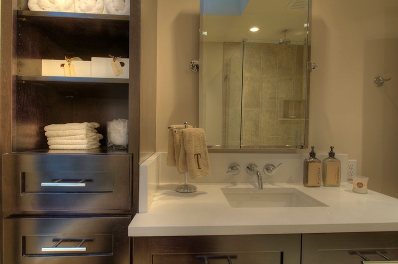 Bathroom with a stainless steel cabinet, white countertop, and mirror.