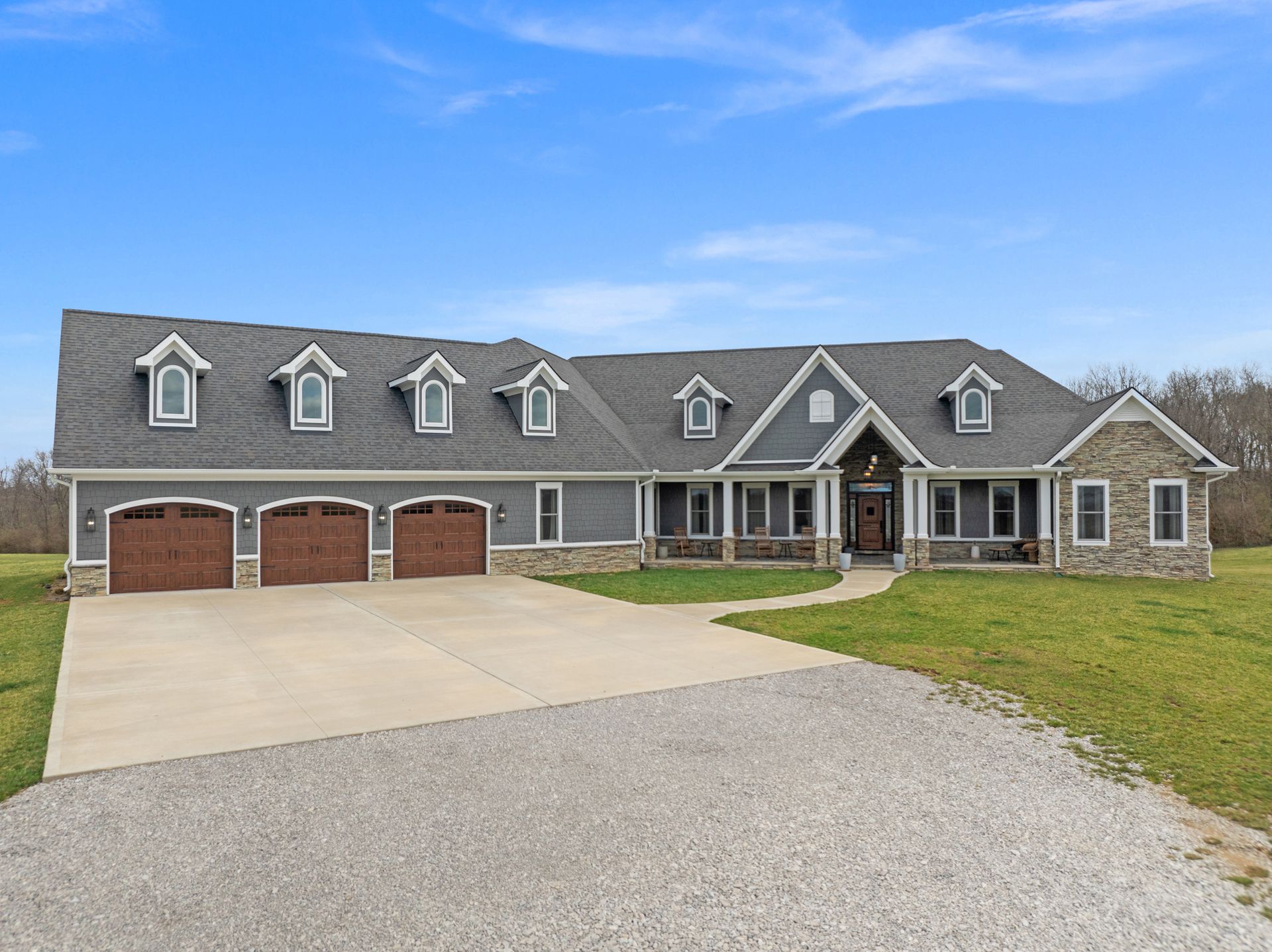 Porch entry with stone columns and a wooden door. Gray stone and dark wood details.