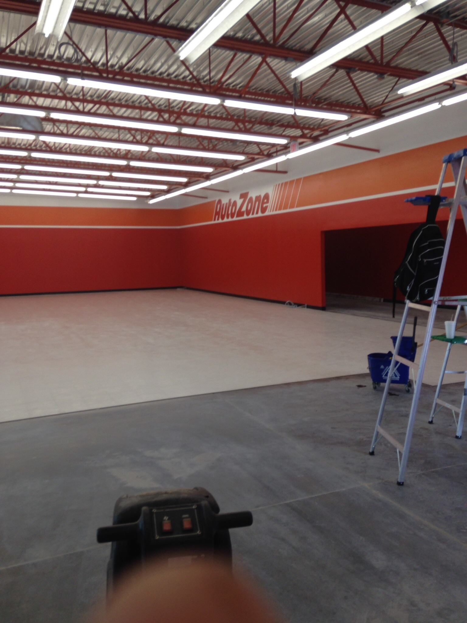 Modern conference room with long wooden table, black chairs, projector screen, and large windows.