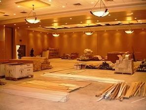 A large, empty room under construction with construction materials scattered on the floor.