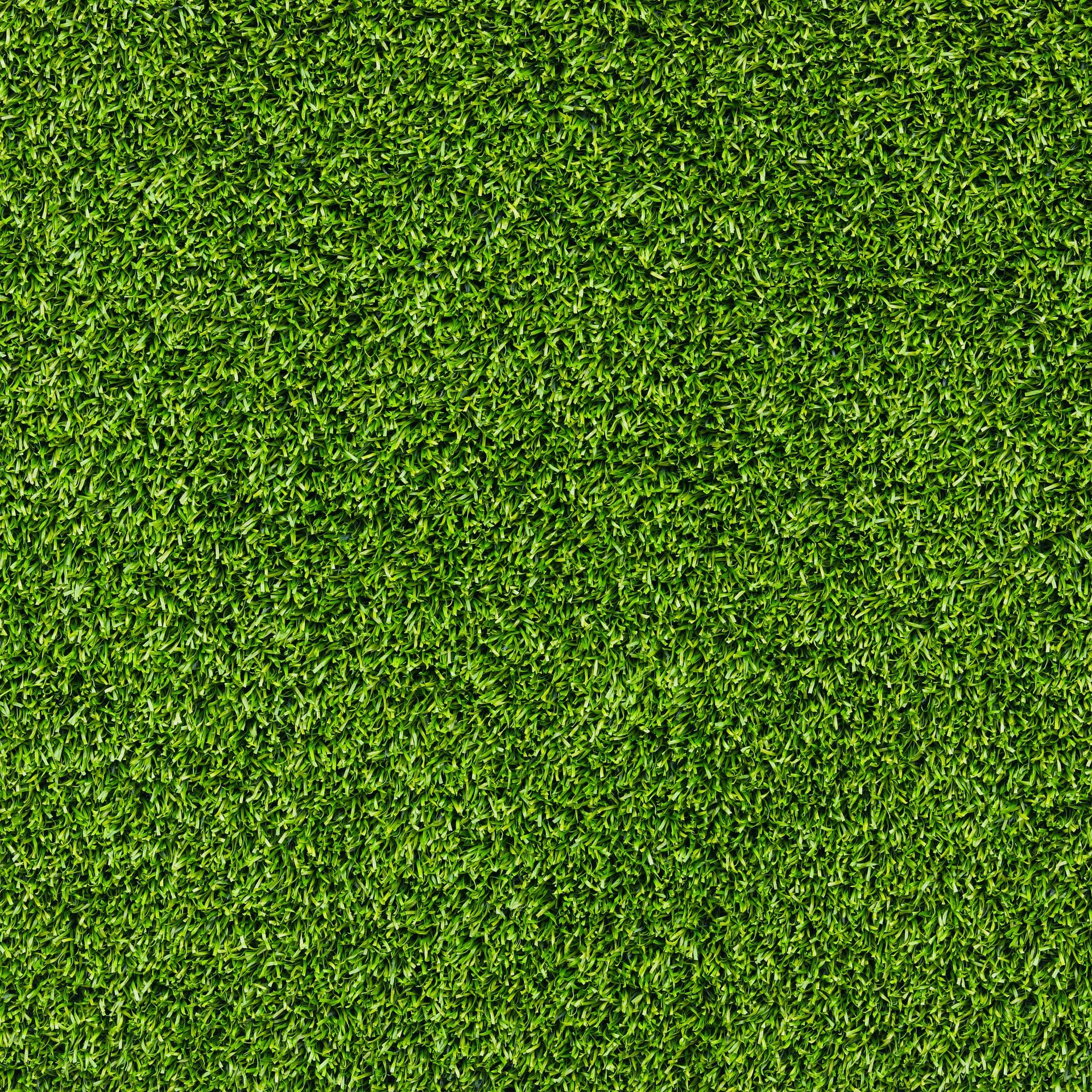 Una texture uniforme di erba sintetica verde brillante o erba appena tagliata.