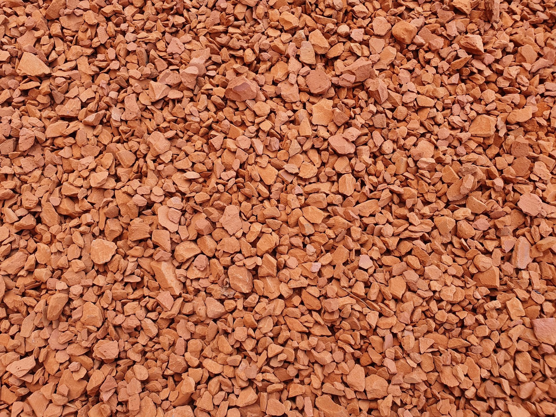 Un primo piano di ciottoli frantumati di colore marrone chiaro e beige che riempiono l'inquadratura.