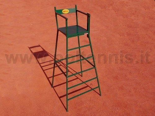 Una sedia da arbitro di tennis verde su un campo in terra battuta rossa.