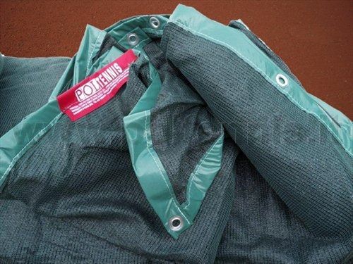 Primo piano di una robusta rete frangivento verde per campi da tennis, con un'etichetta rossa del marchio 