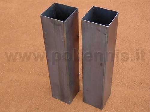 Due tubi metallici quadrati sono posizionati verticalmente su uno sfondo ruvido di colore bruno-rossastro.