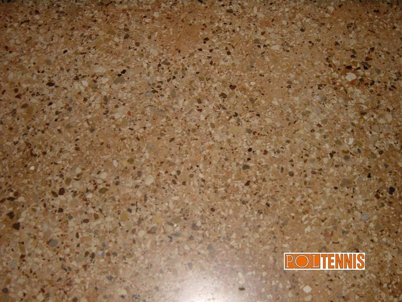 Primo piano di un piano di lavoro in granito o laminato marrone e screziato, con venature chiare e scure che ricordano la pietra.