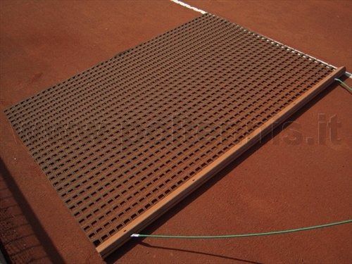 Un tappeto metallico per livellare e mantenere un campo da tennis in terra battuta rossa.