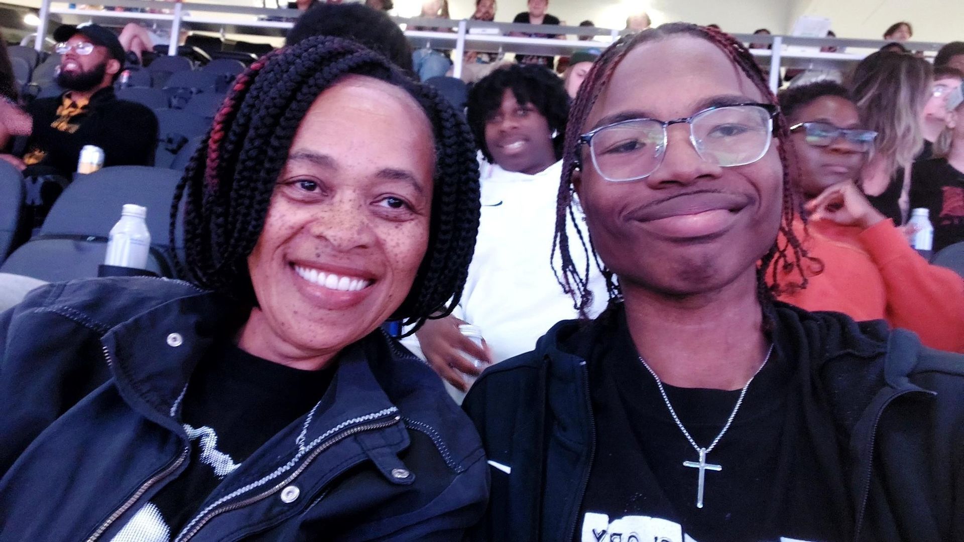 A man and a woman are posing for a picture in a stadium