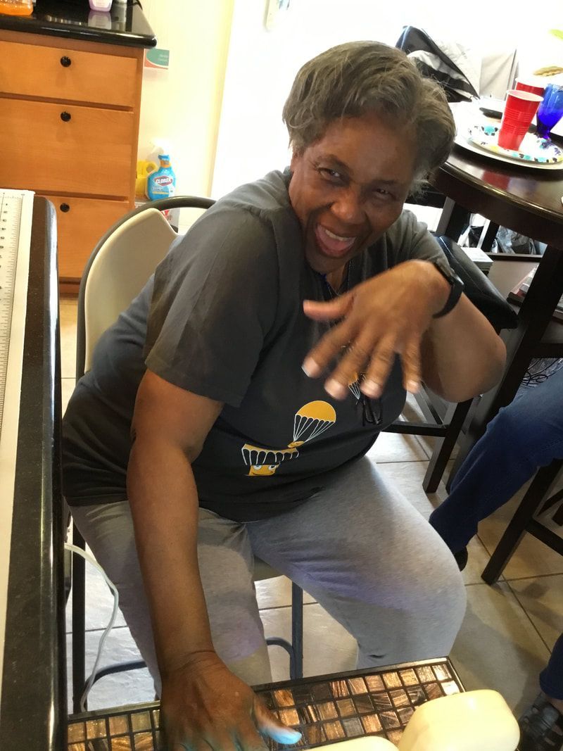 A woman in a gray shirt is sitting at a table