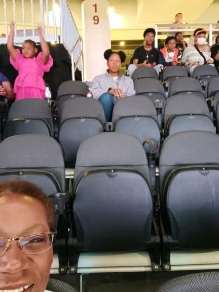 A group of people are sitting in a stadium with the number 19 in the background