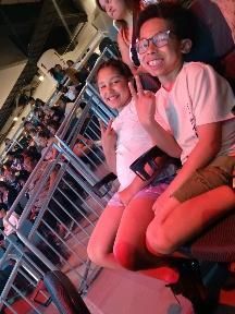 A boy and a girl are sitting next to each other in a stadium.