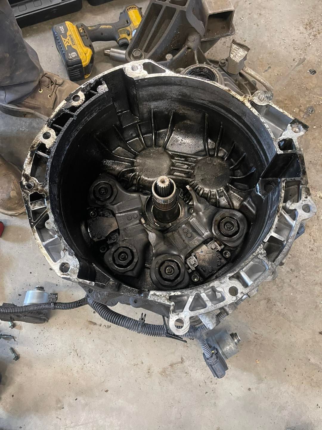 A close up of a broken gearbox on the ground.